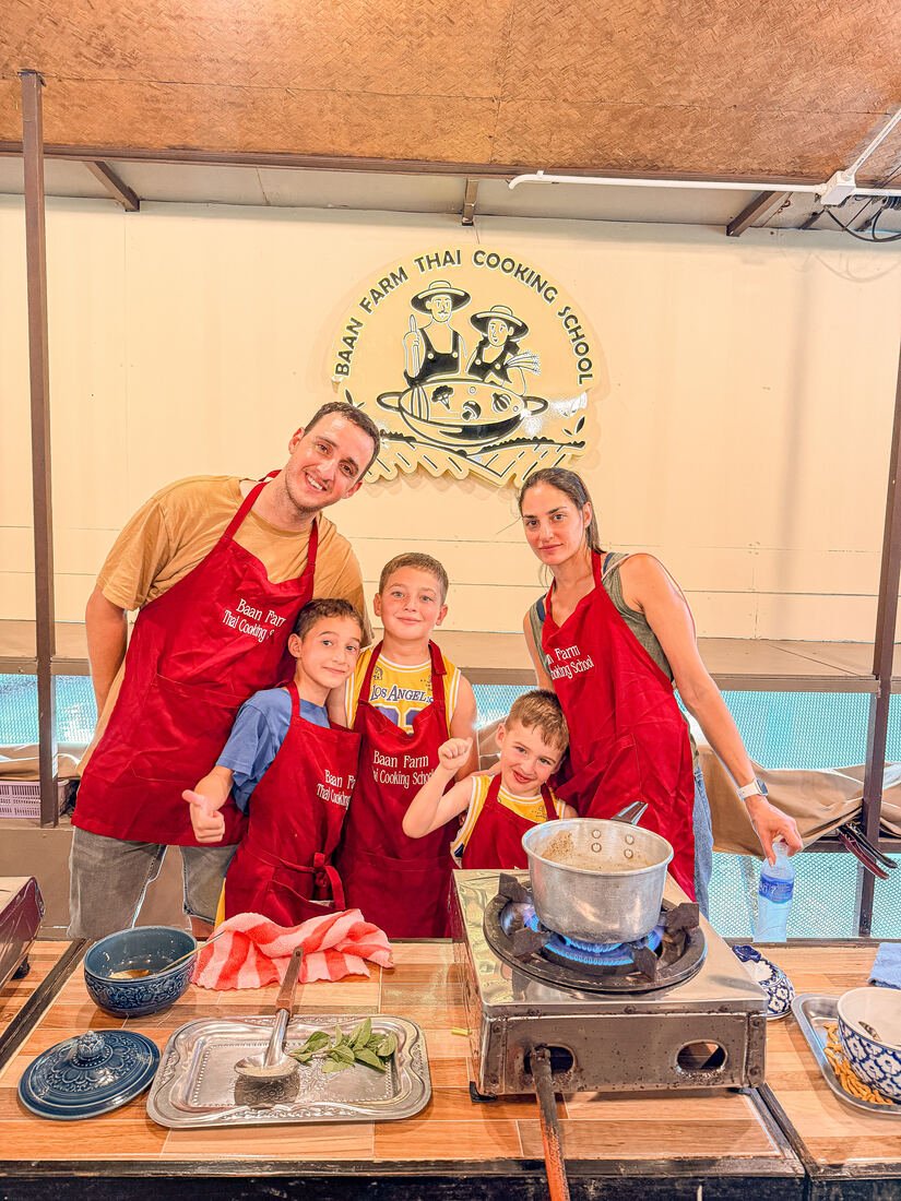 A family posing with their finished dishes at Baan Farm Thai Cooking School