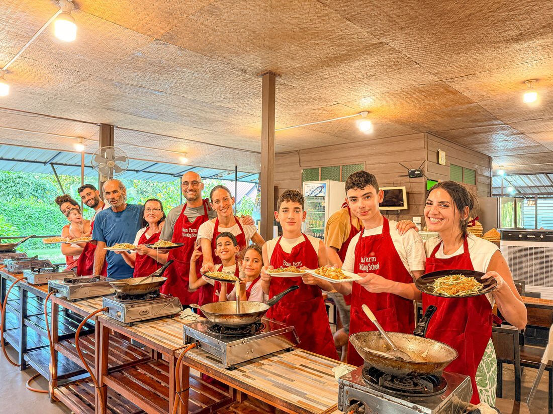 Guests and instructors cooking together at Baan Farm Thai Cooking School