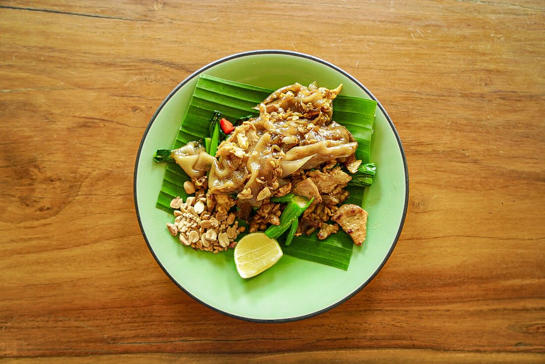 Stir-fried Thai dish plated on a banana leaf at Baan Farm Thai Cooking School