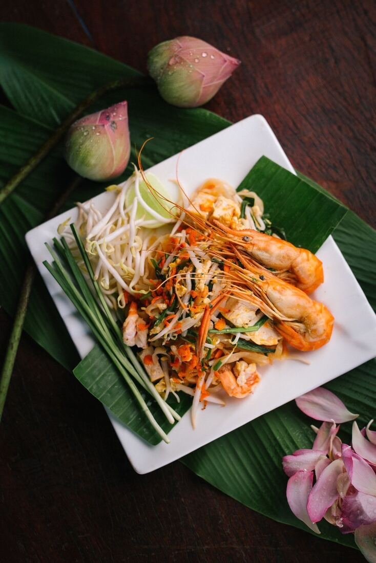 Stir-fried shrimp dish plated with fresh herbs at Baan Farm Thai Cooking School